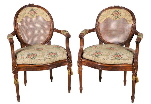 Pair of antique French walnut armchairs carved with Louis XVI motifs, with medallion backs and fluted legs, canneté cover with cushions in floral fabric