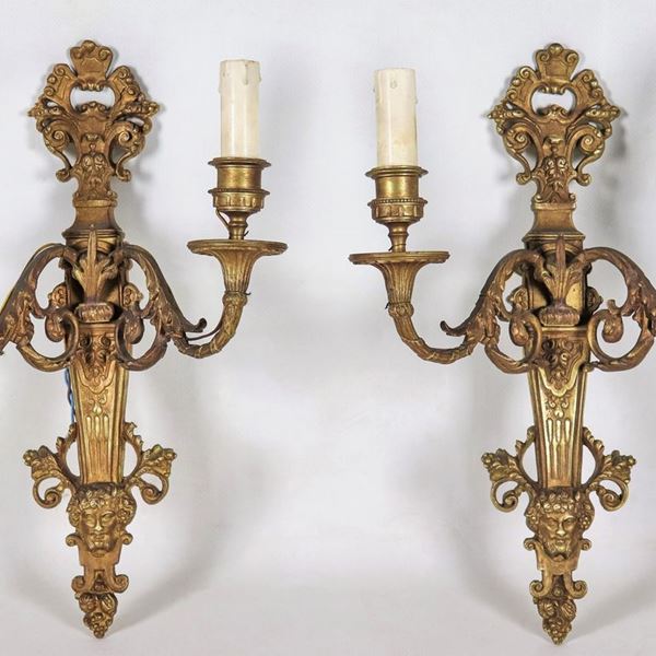 Coppia di appliques francesi  in bronzo dorato, sbalzato e cesellato con mascheroni, 2 luci ciascuna