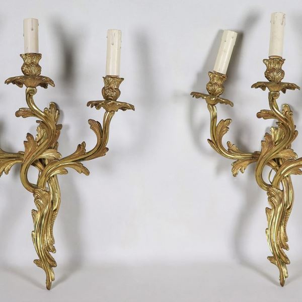 Coppia di appliques francesi in bronzo dorato e sbalzato a motivi Luigi XV, 3 luci ciascuna