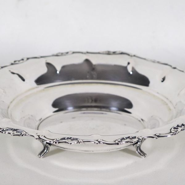Piccolo centrotavola tondo in argento con bordo cesellato e sbalzato a volute, sorretto da tre piedini ricurvi, gr. 245