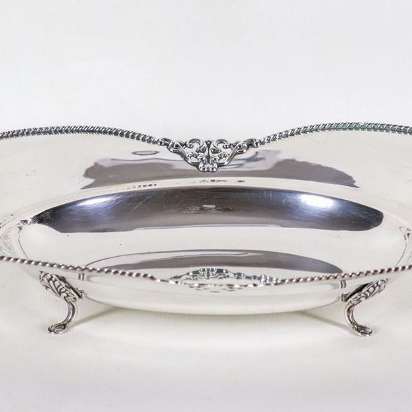Shaped centerpiece in silver with chiseled and embossed edge with volutes and fretwork, supported by four curved feet, gr. 460