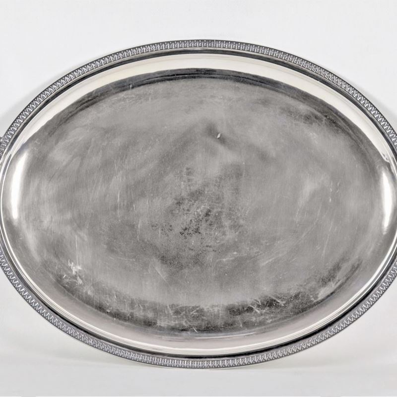 Grande vassoio ovale in argento con manici e bordi cesellati e sbalzati a motivi Impero, gr. 1850
