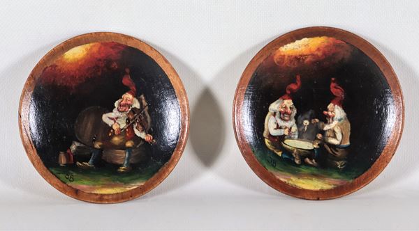 Coppia di piattini in legno dipinti ad olio con figure di "Gnomi". Siglati