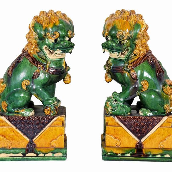 Coppia di sculture cinesi "Cani Foo" in porcellana verde e ocra