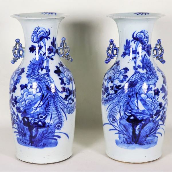 Pair of Chinese porcelain vases with blue decorations with motifs of exotic flowers and parrots, slight chipping on the neck of one vase