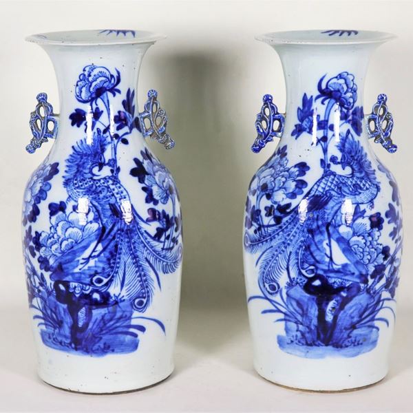 Coppia di vasi cinesi in porcellana con decorazioni in blu a motivi di fiori esotici e pappagalli, lieve sbeccatura al collo di un vaso