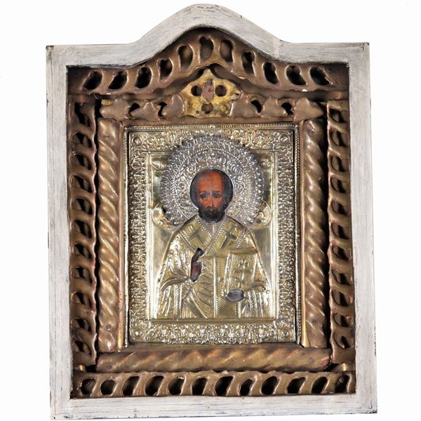 "St. Nicholas the Wonderworker", an ancient Russian icon painted on a panel with a golden, embossed and chiseled metal lashing, in a travel showcase frame missing the glass