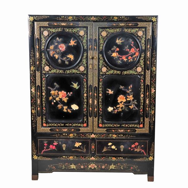 Stipo giapponese in legno laccato nero, con decorazioni e applicazioni di pietre dure e giade , due sportelli e due tiretti sottostanti