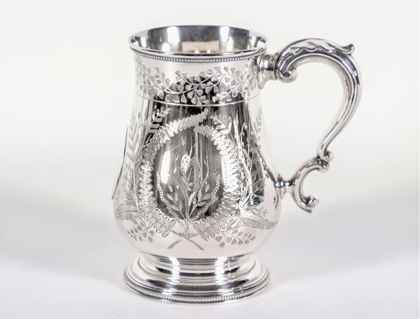 Queen Victoria period tankard in chiseled and embossed silver with leaf and flower motifs, monogram in the center and curved handle, gr. 275