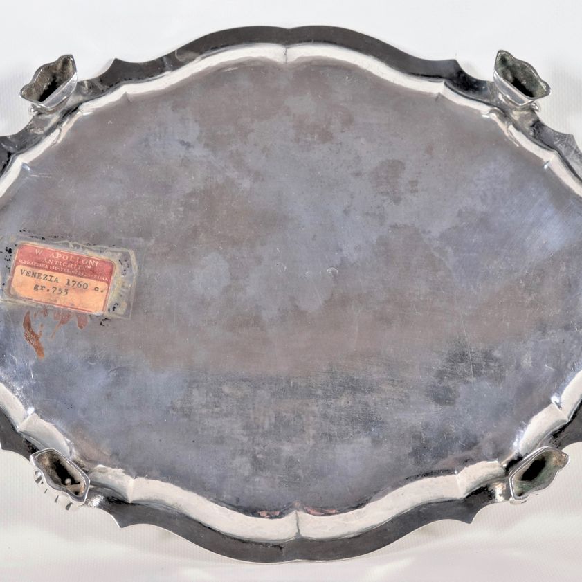 Antico vassoio ovale in argento con bordo centinato e sbalzato, sorretto da quattro piedini leoni...