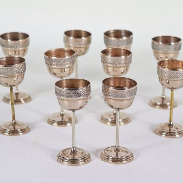 Lot of twelve goblet-shaped liqueur glasses in silvered and chiselled metal