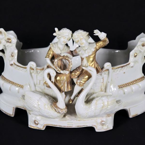 Piccolo centrotavola portafiori in porcellana Capodimonte bianca e oro, con sculturine di bambini e cigni