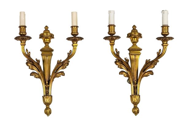 Pair of French sconces in gilded bronze, chiseled and embossed with Louis XVI motifs of amphorae and leaves, 2 lights each