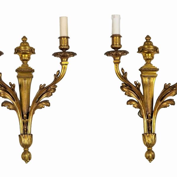 Coppia di appliques francesi in bronzo dorato, cesellato e sbalzato a motivi Luigi XVI di anfore e foglie, 2 luci ciascuna