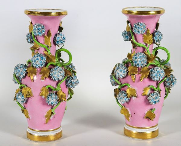 Pair of antique small French vases in pink porcelain, with applications in relief of intertwining flowers and leaves, defects