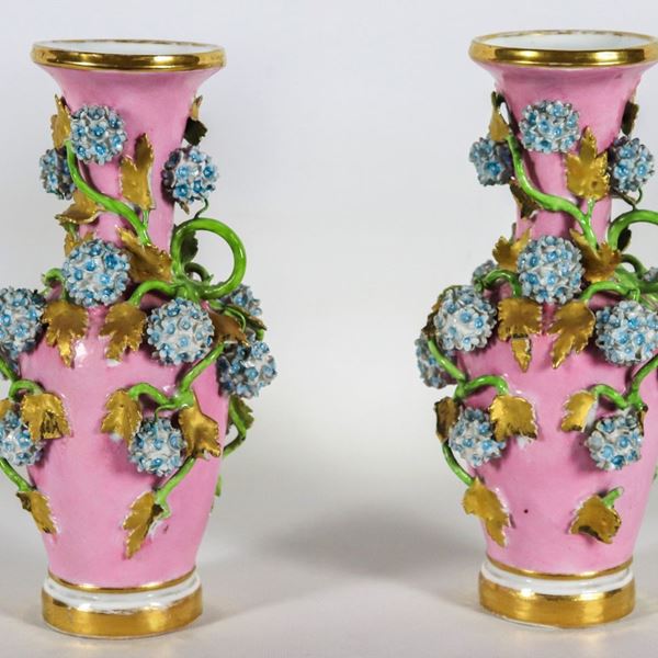 Coppia di antichi piccoli vasi francesi in porcellana rosa, con applicazioni a rilievo di intrecci di fiori e foglie, difetti