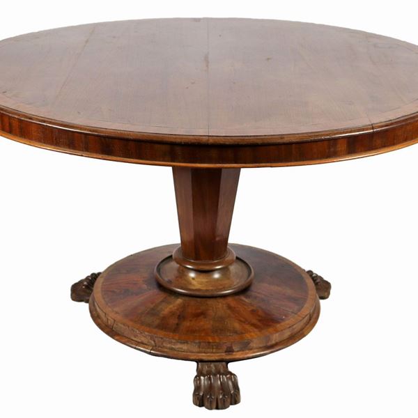 Round English dining table of the Regency line in walnut, with inlaid band on the satin wood top, supported by a faceted column base, resting on a circular top with three leonine legs