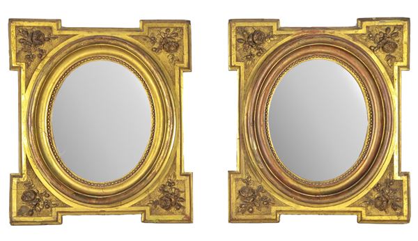 Pair of antique oval frames in gilded and carved wood with motifs of bunches of roses, with mirrors inside