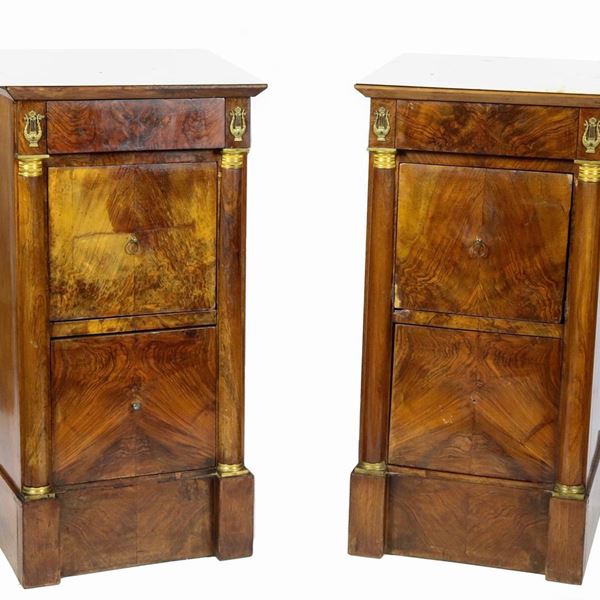 Coppia di comodini toscani Impero in mogano e piuma di mogano, con tiretto centrale, sportellino ribaltabile e cassetto sottostante, montanti con colonnine neoclassiche e piano in marmo bianco statuario