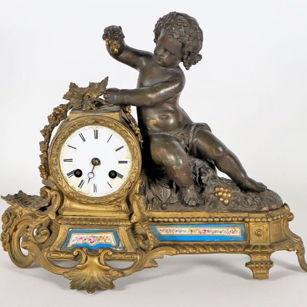 Pendola francese da tavolo in bronzo patinato e dorato, con scultura di giovane Bacco e placchette in porcellana dipinta di Sèvres, quadrante in smalto bianco