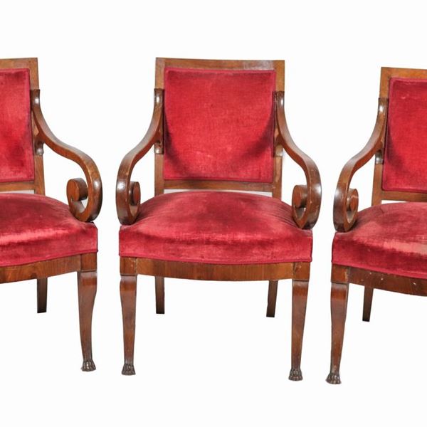 Lotto di tre poltrone Impero in noce, con braccioli ricurvi e gambe terminanti a zampa leonina, copertura in velluto rosso
