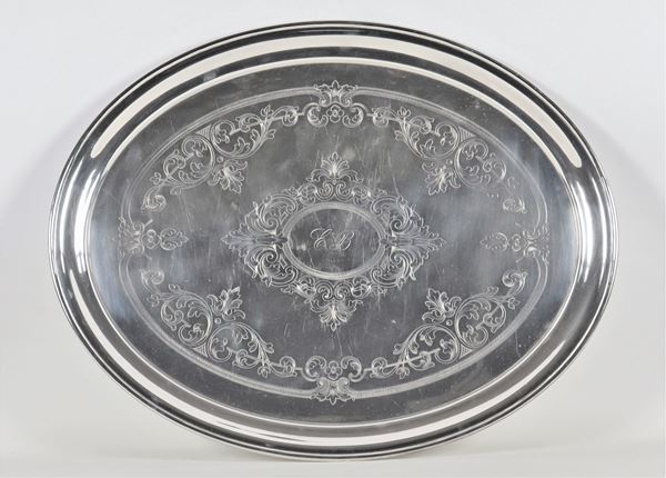 Large oval tray in silver-plated metal, with a base engraved with floral scrolls and a central monogram
