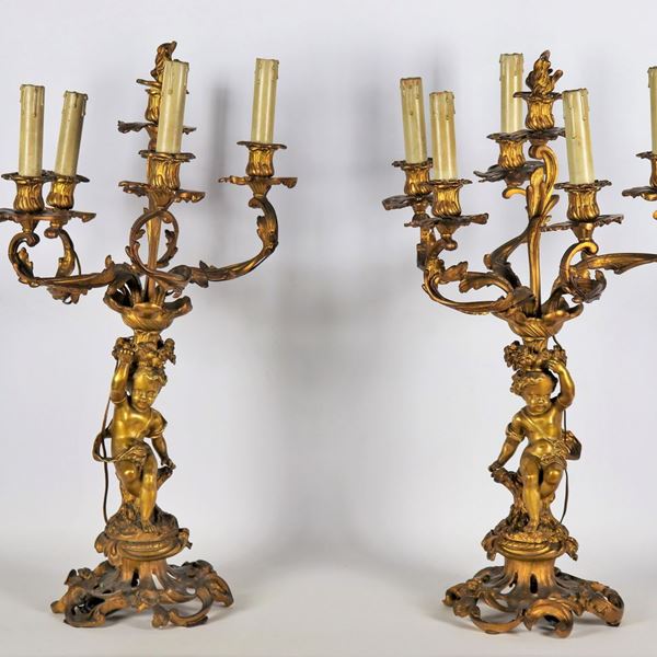 Coppia di antichi candelabri in bronzo dorato, sbalzato e cesellato con sculture di putti, 6 fiamme ciascuno