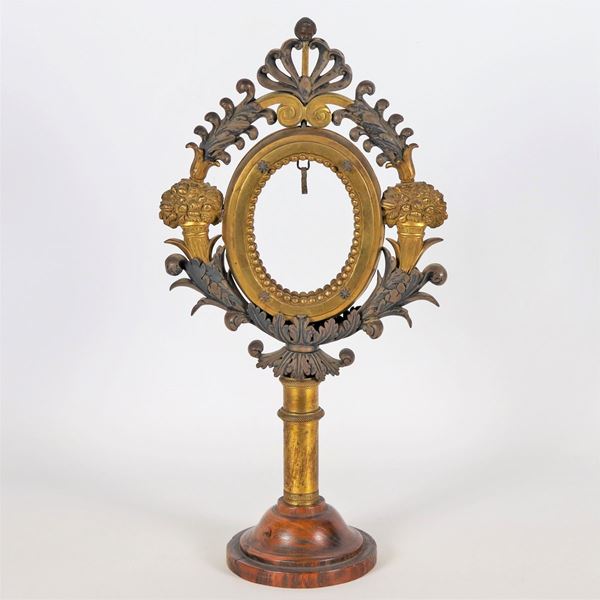 Antico portareliquie romano in bronzo patinato e dorato, sbalzato e cesellato a motivi di cornucopie con fiori e palmette