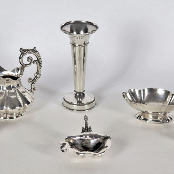 Lot in chiseled and embossed silver of a jar, three salt shakers, a milk jug and a shell (6 pcs), gr. 310