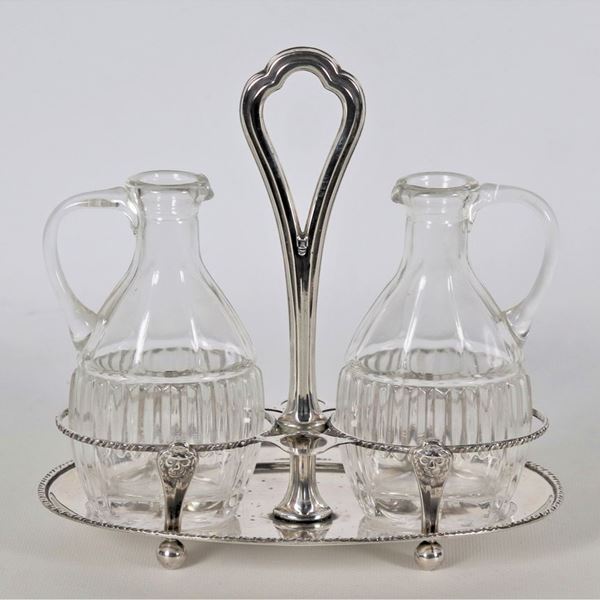 Chiselled and embossed silver oil cruet with Empire motifs, two crystal cruets missing caps, gr. 175