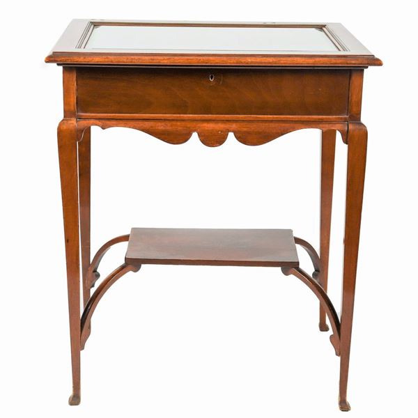 English showcase table in mahogany with four legs joined by a small shelf below