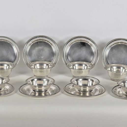 Lotto di dodici coppe con piattini in argento con bordi cesellati, sbalzati e traforati, gr. 3790