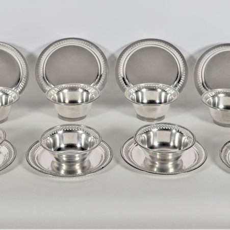 Lotto di dodici coppe con piattini in argento con bordi cesellati, sbalzati e traforati, gr. 3790
