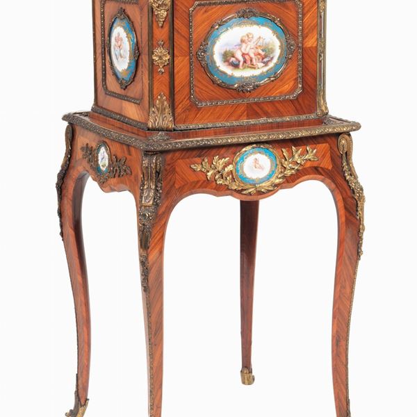 Bonheur du jour francese da centro Napoleone III (1852-1870) in ebano viola, con applicazioni di nove placche in porcellana di Sèvres dipinte con scene di "Allegorie di putti", guarnizioni e fregi in bronzo dorato e cesellato, pianetto superiore apribile, piccola calatoia formante scrittoio e quattro gambe ricurve
