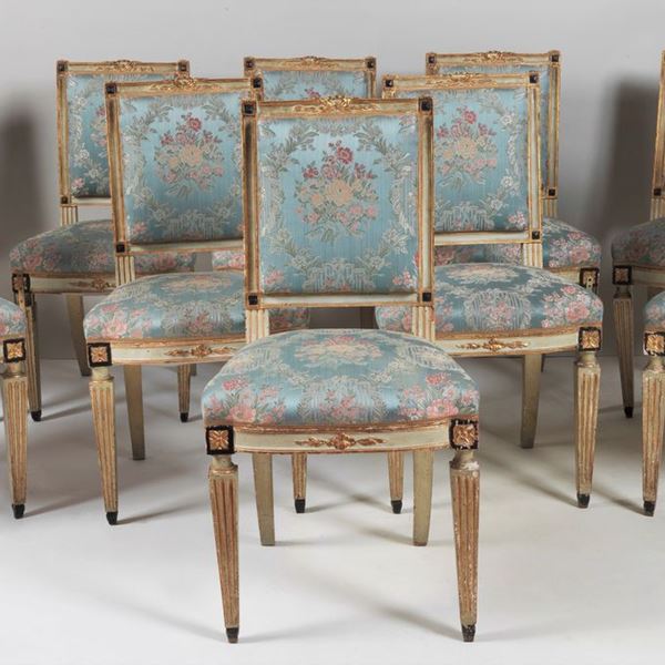 Lotto di dieci sedie di linea Luigi XVI in legno laccato avorio e dorato, con intagli a motivi neoclassici, copertura in tessuto fiorato