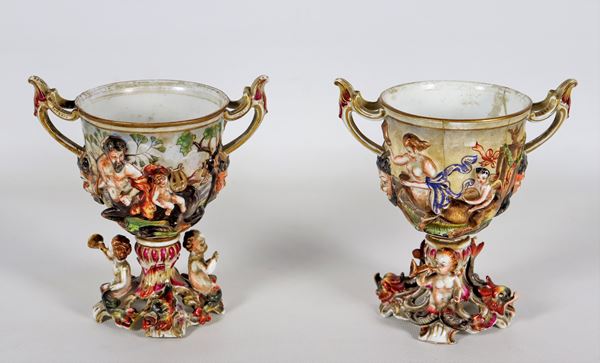 Pair of Capodimonte polychrome porcelain cups, with mythological figures in relief. Defects and breaks