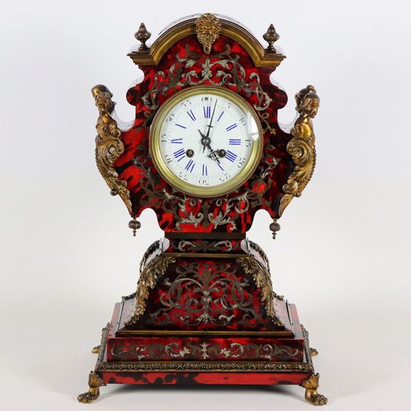 Antique French table clock with inlays in gilded metal with Boulle motifs, gilt bronze seals, mask and statuettes of ladies and knights, four leonine feet and white enamel dial with Roman numerals