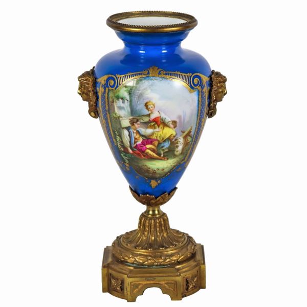 Amphora-shaped vase in turquoise Sèvres porcelain, with painted medallions of pastoral scene and bunches of flowers, highlights in pure gold, handles in the shape of masks and base in gilded and chiselled bronze