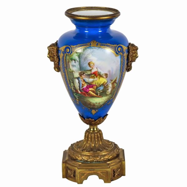 Vaso ad anfora in porcellana turchese di Sèvres, con medaglioni dipinti di scena pastorale e mazzetti di fiori, lumeggiature in oro zecchino, manici a forma di mascheroni e base in bronzo dorato e cesellato