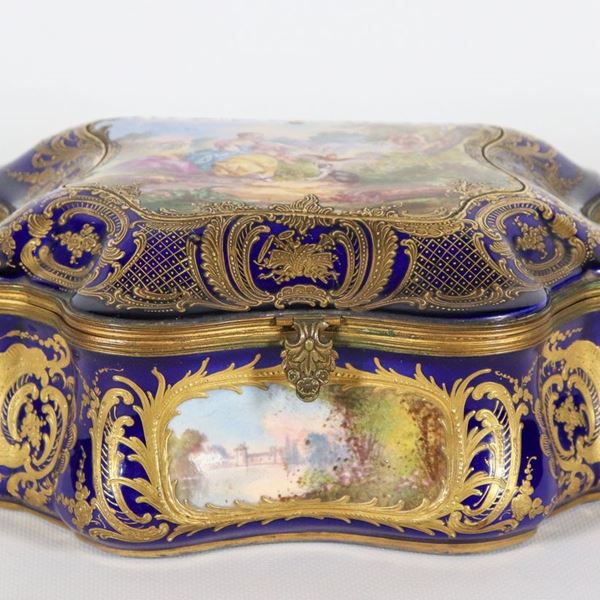 Large box in cobalt blue Sèvres porcelain, with relief highlights in pure gold and painted scenes of landscapes, painted scene "Lady with child and dog" on the lid