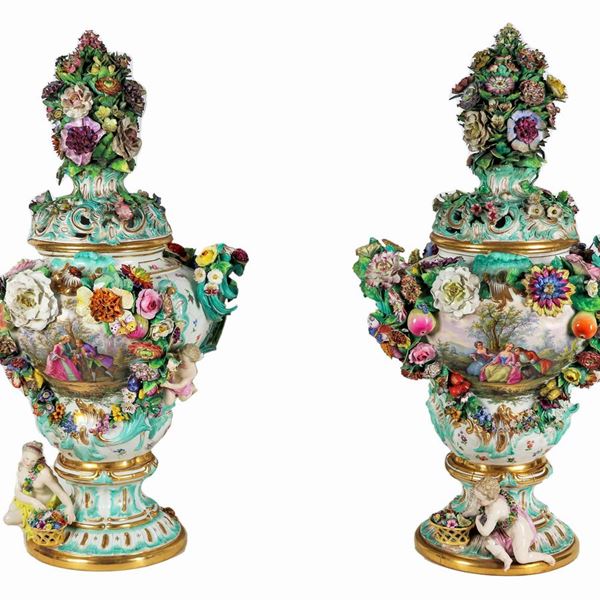Coppia di grandi potiches in porcellana policroma Meissen, con scene galanti dipinte e interamente decorati con applicazioni a rilievo di statuine, fiori e frutta. Rotture e varie mancanze 