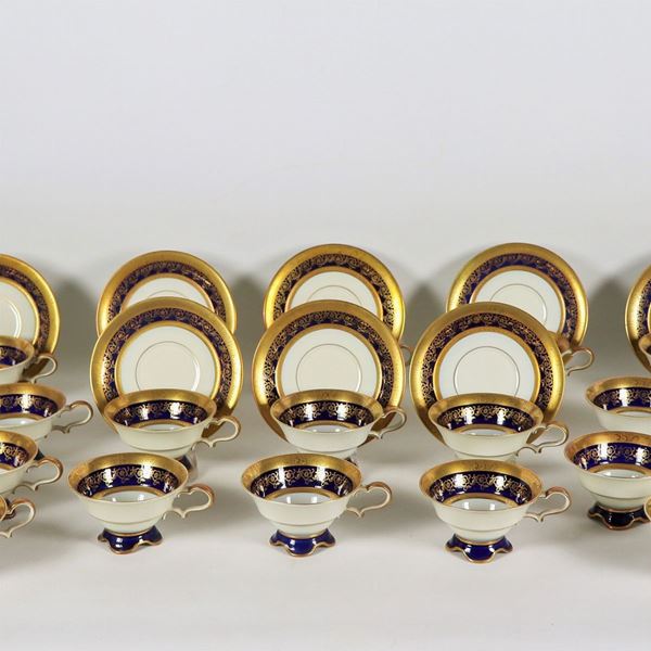 Servizio di 24 tazze da tè con piattini e 26 piatti da dolce in porcellana tedesca, con bordi in oro zecchino e fascia in blu cobalto con intrecci floreali (50 pz)