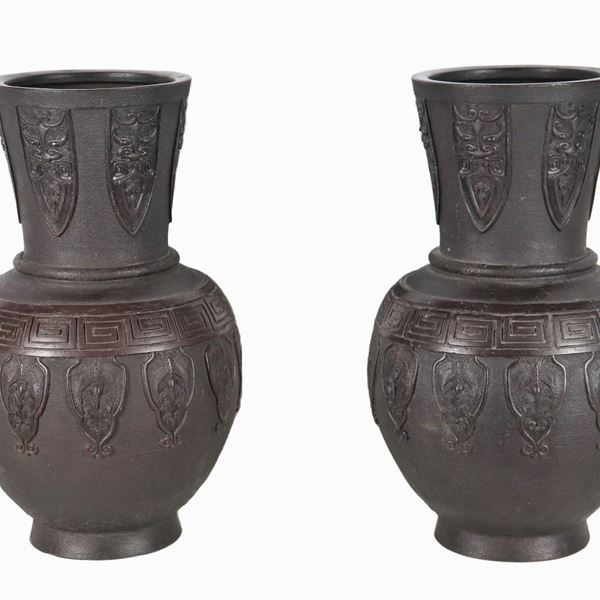 Coppia di vasi cinesi in terracotta patinata nera, con decorazioni a rilievo a motivi orientali