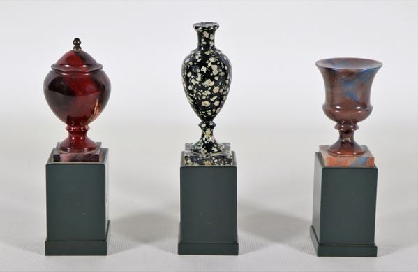 Lotto di tre modellini di vasi e anfore a vari marmi policromi, sorretti da basette quadrangolari
