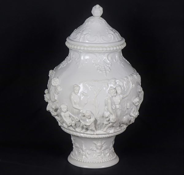 Vaso con coperchio in porcellana bianca smaltata Capodimonte, con scene di baccanale a rilievo