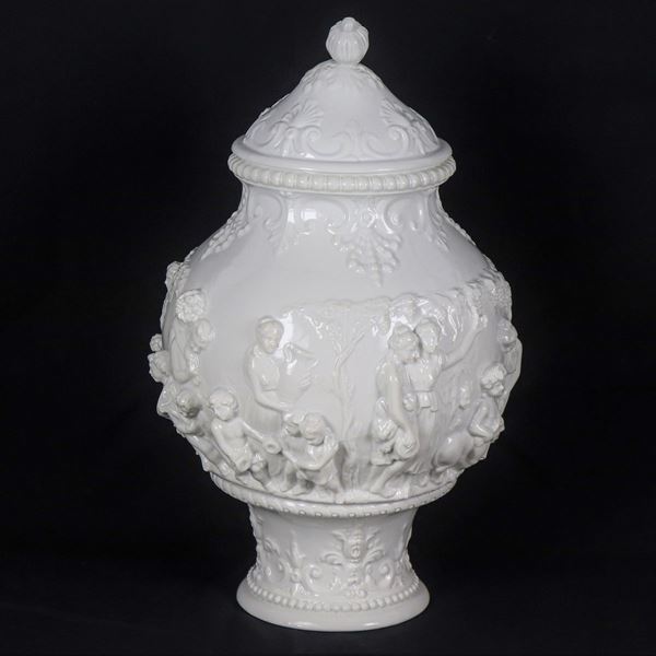 Vase with lid in white Capodimonte glazed porcelain, with bacchanal scenes in relief