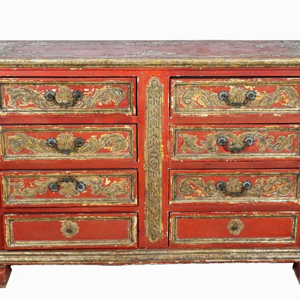 Canterano spagnolo di linea Luigi XIV in legno laccato rosso con intagli a rilievo dorati, otto tiretti