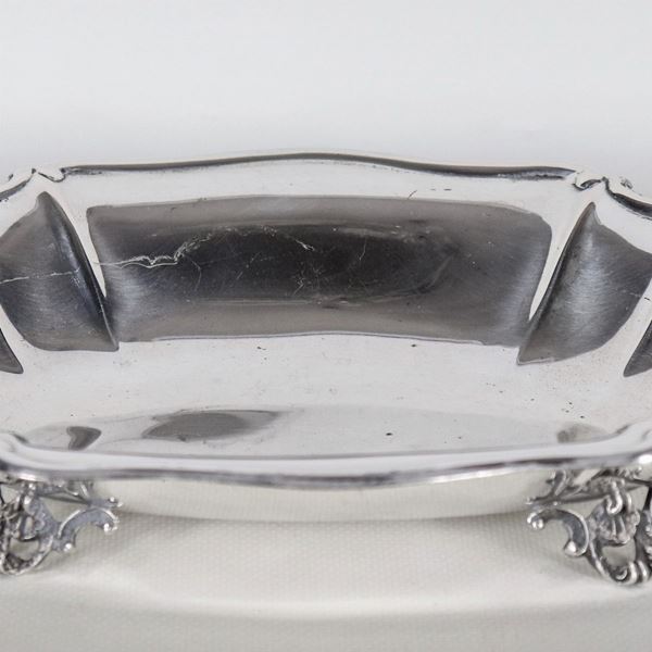 Piccolo centrotavola ovale in argento con bordo centinato, sorretto da quattro piedini sbalzati, gr. 290