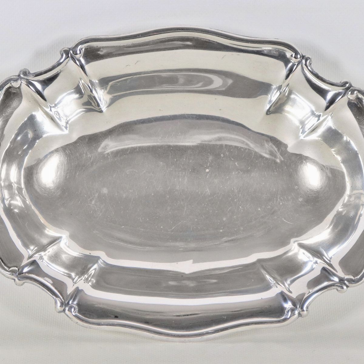 Piccolo centrotavola ovale in argento con bordo centinato, sorretto da quattro piedini sbalzati, ...