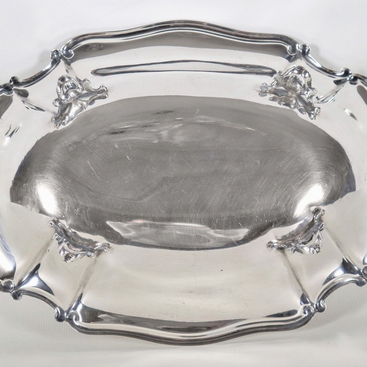 Piccolo centrotavola ovale in argento con bordo centinato, sorretto da quattro piedini sbalzati, ...